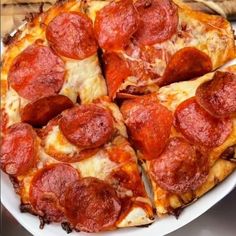 a pepperoni pizza cut into four slices on a white plate