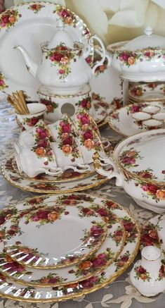 a table topped with lots of white plates and dishes covered in floral designs on top of each other