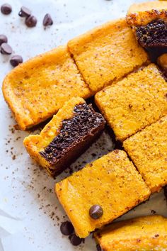 slices of pumpkin brownies on a plate with chocolate chips and coffee beans around them