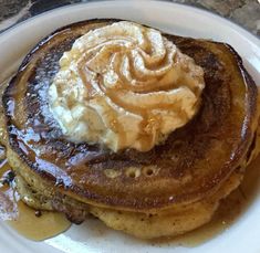 pancakes with butter and syrup on top are sitting on a plate, ready to be eaten