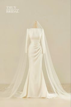 the back of a wedding dress with a long veil on it's head and shoulders