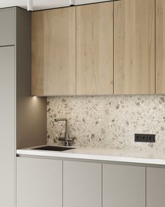 a kitchen with white counter tops and wooden cabinets in the back drop off cabinetry