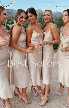 three beautiful women standing next to each other holding wine glasses