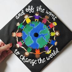 a black graduation cap with children holding hands around the earth and saying, and off she went to change the world