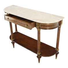 an antique console table with marble top and gold trimmings on the bottom shelf