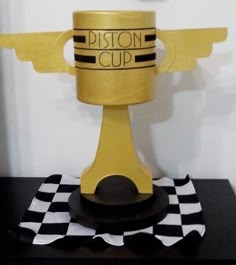 a golden cup sitting on top of a black and white checkerboard tablecloth