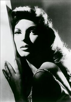 black and white photograph of a woman leaning against a wall