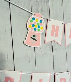 a pink and white birthday banner hanging from a string on a wooden wall with paper bunting