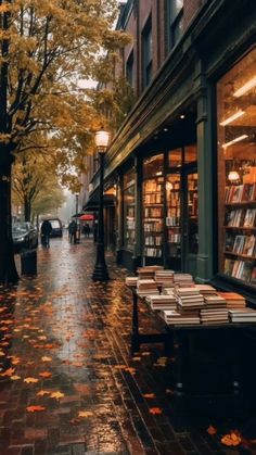 an empty sidewalk in the rain with books on it