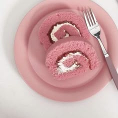 a pink plate with two pieces of cake on it and a fork next to it