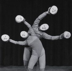 two people are balancing on their hands with balls in the shape of four heads and arms