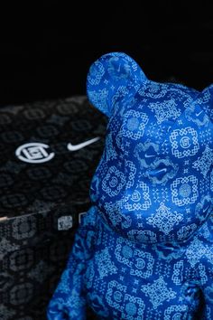 a blue teddy bear sitting next to a black box