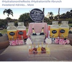 a table topped with drinks and fruit on top of a metal tray covered in plastic bottles