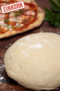 a pizza sitting on top of a wooden table next to a doughnut covered in toppings