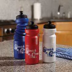 three water bottles sitting on top of a counter next to a blue and red towel