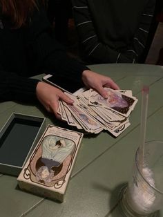 a table topped with cards and a drink