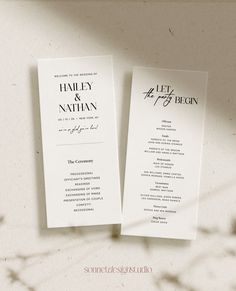 two wedding program booklets sitting next to each other on top of a white table