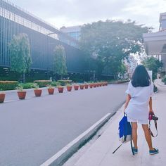 the woman is walking down the street with her umbrella in hand while holding an umbrella