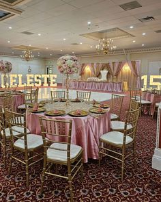 a banquet hall with tables and chairs covered in pink cloths