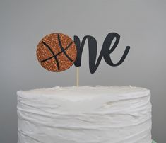 there is a cake with a basketball on it and the word one written in cursive letters