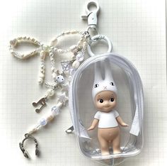 a keychain with a small doll inside of it