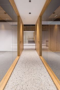 an empty hallway with wood and glass walls