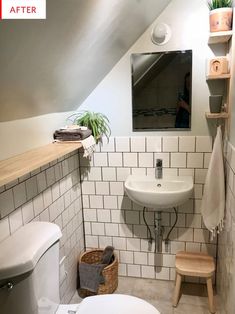 a white toilet sitting next to a sink in a bathroom under a slanted ceiling