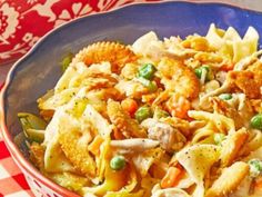 a bowl filled with pasta and vegetables on top of a red checkered table cloth