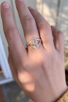 a woman's hand with a ring on it and a diamond in the middle