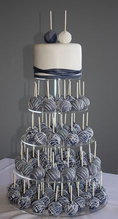 there is a cake with blue and white frosting on the top, surrounded by lollipops