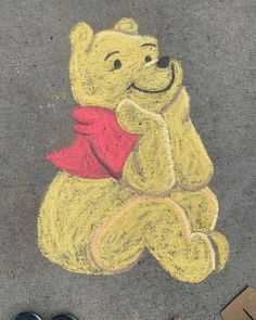 a drawing of a teddy bear on the ground with someone's feet next to it