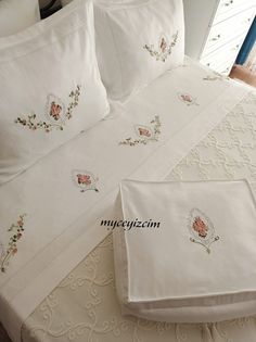 a bed with white sheets and pillows on top of it