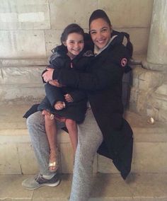 two women sitting on a bench with their arms around each other