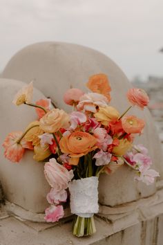 a bouquet of flowers sitting on top of a stone bench