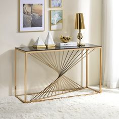 a gold and black console table with pictures on the wall