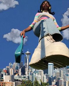 a woman standing on top of a giant object in front of a cityscape