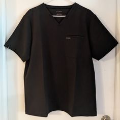 Nwot. V-Neck, Hidden Badge Loop, Ribbed Neck And Pocket Hem. Pocket On Front Left Chest With Pencil Pocket Inside. 22.5" Armpit To Armpit. 28" In Length. Black Short Sleeve Tops With Welt Pockets, Casual V-neck Tops With Side Pockets, Black Cotton Tops With Welt Pockets, Black Workwear Tops With Pockets, Relaxed Fit T-shirt With Pockets For Workwear, Relaxed Fit Workwear T-shirt With Pockets, Black Relaxed Fit Top With Side Pockets, Hidden Pocket, Scrub Tops