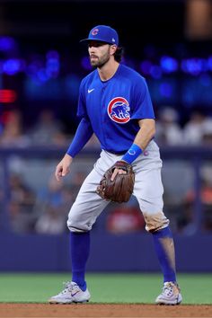 a baseball player standing on top of a field wearing a catcher's mitt