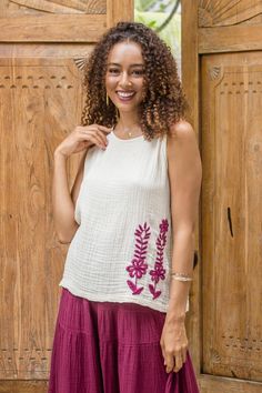 Hand-stitched on antique white double-layered crinkled cotton, the floral motif on Ying and Joy's summery blouse is a splendid example of Thai craftsmanship. Mulberry-colored flowers and vines decorate the front while a larger embroidered trellis pattern decorates the back. The top matches expertly with the mulberry tiered skirt, all part of Ying and Joy's stylish separates collection. Sleeveless Floral Embroidered Top For Summer, Embroidered Off White Summer Tops, Off White Embroidered Summer Tops, Summer Sleeveless Embroidered Cotton Top, Summer Off White Top With Floral Embroidery, Off White Floral Embroidered Top For Summer, Off White Sleeveless Summer Blouse, Off White Sleeveless Blouse For Spring, Embroidered Cotton Top