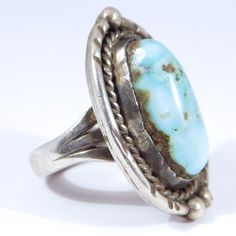 This ring has a wonderful design! Attributed to Navajo but no markings, acid tests sterling silver and the color of the turquoise is a wonderful light blue that is hard to find! Measures 1.25 inches by ¾ inch and it is a size 6 and weighs 12.5 grams. Very good condition. Nice quality to this one, if you want a great size wearable vintage turquoise ring this is an excellent example. Blue Untreated Southwestern Rings, Collectible Untreated Blue Turquoise Ring, Southwestern Style Untreated Blue Turquoise Ring, Antique Turquoise Sterling Silver Ring, Vintage Sterling Silver Turquoise Ring With Large Stone, Antique Untreated Turquoise Ring In Silver, Antique Style Untreated Silver Turquoise Ring, Antique Style Silver Turquoise Ring, Vintage Turquoise Ring