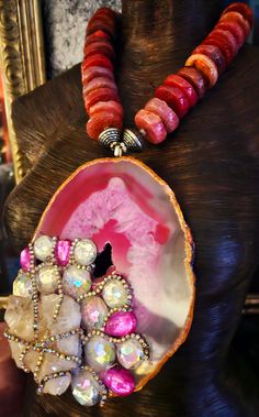 After a re-stringing repair, this piece is now ready for a new home! A 7" x 5" hot pink and Fuchsia Brazilian agate hosts a rough white quartz cluster, faux clear and pink crystals and rows of silver aurora borealis rhinestones! The pendant is suspended from an agate rondelle statement necklace which measures 21". The reddish-pink agates are polished on one side and rough on the other. Each agate is spaced with an ornate silver tone metal bead. Flanking the pendant are rhinestone rondelles and silver tone stamped tribal bi-cone beads. The back is finished with more tribal beads, rhinestone rondelles, frosted pink druzy agates and clear faceted crystals. Closes with a fancy silver tone hook and eye. This is a very dense and heavy piece so please know your tolerance before you buy. From the Unique Pink Ruby Jewelry, Artisan Pink Gemstone Beads Jewelry, Artisan Pink Gemstone Jewelry, Red Agate Stone Necklace, Pink Agate Gemstone Jewelry, Unique Pink Gemstone Beads Jewelry, Rocker Chic Accessories, Statement Necklace Wedding, Brazilian Agate