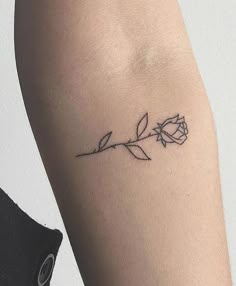 a small rose tattoo on the arm