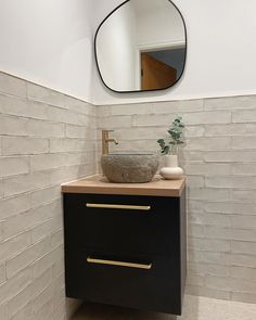 a bathroom sink with a mirror above it and a vase on the counter next to it