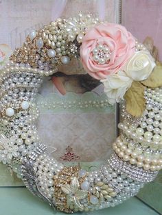 a close up of a wreath made out of pearls and other items on a table