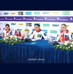 three women sitting at a table with microphones in front of them