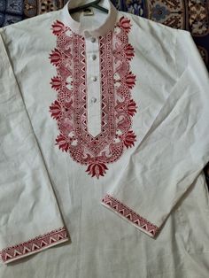 a white shirt with red embroidery on it