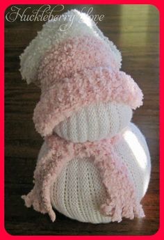 two knitted hats are stacked on top of each other, one is pink and the other is white