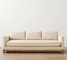 a white couch sitting on top of a hard wood floor