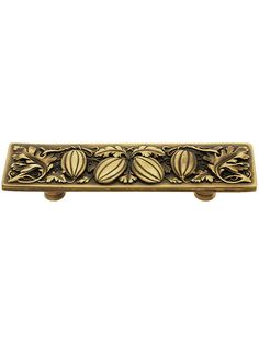 an ornate brass drawer pull with three leaves on it