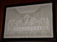 a cross stitch picture with people eating at a long table in front of a window